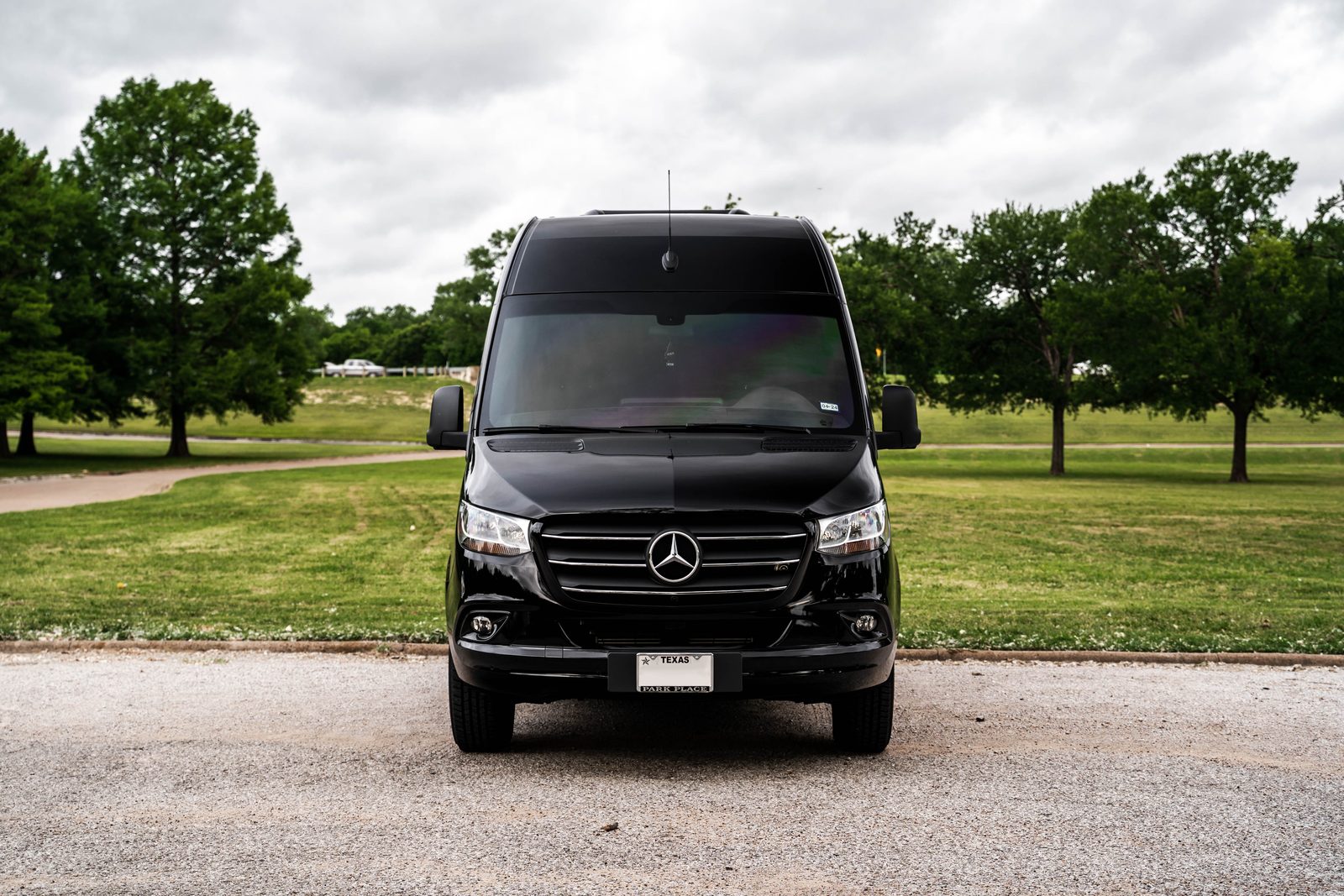 Front view of a black Mercedes-Benz Sprinter with Texas plates