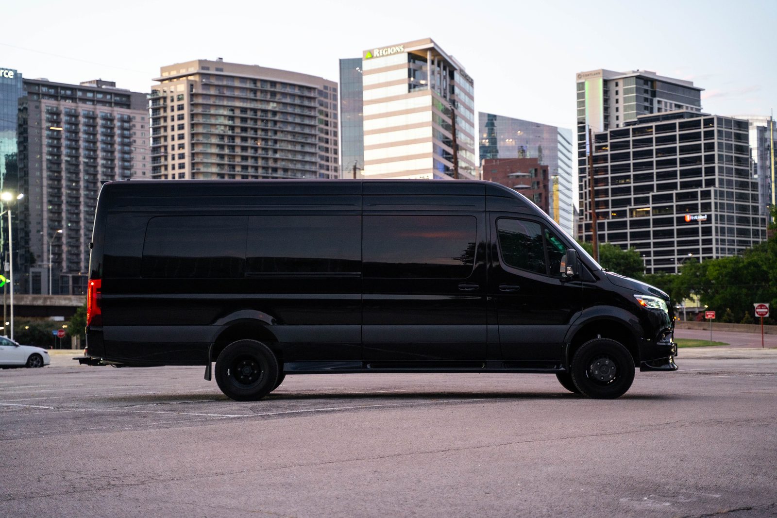 Black Limo Sprinter parked on a city street at dusk