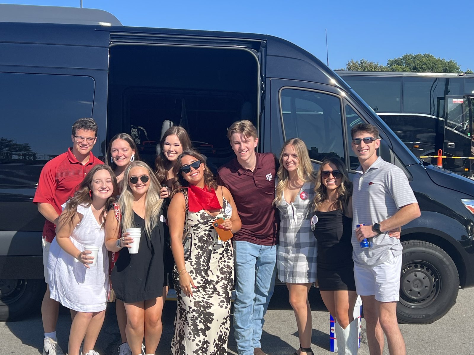 Group of passengers smiling in front of a black Eezy Sprinter
